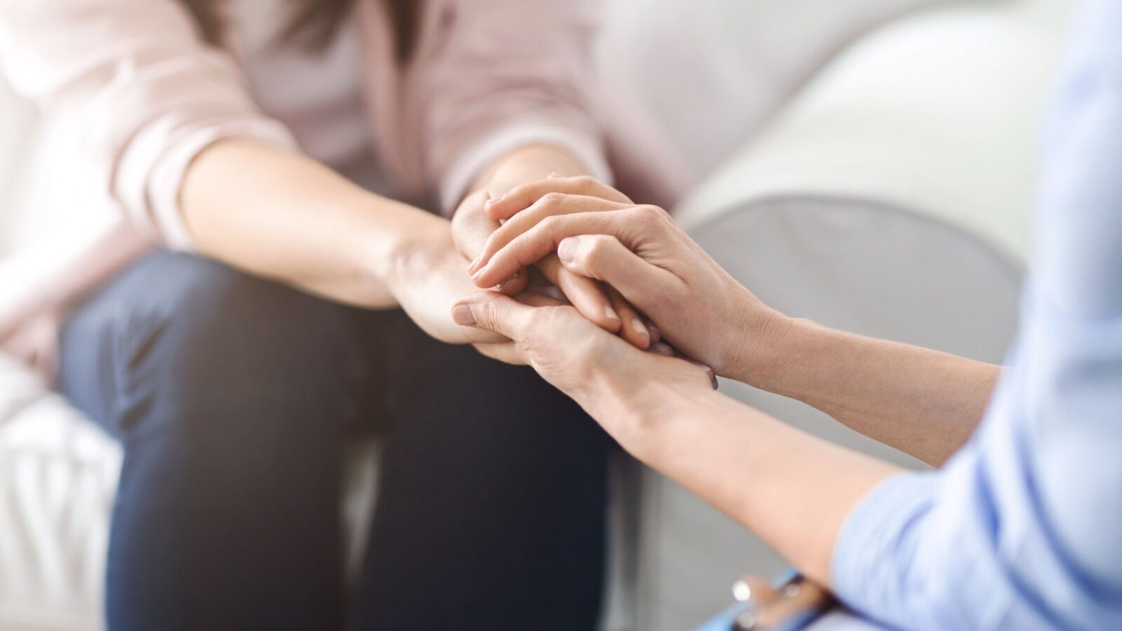 Woman offers comfort and reassurance by holding another woman hand